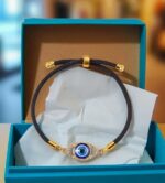 black adjustable bracelet with a blue evil eye  charm set in a gold-tone frame - Image 3