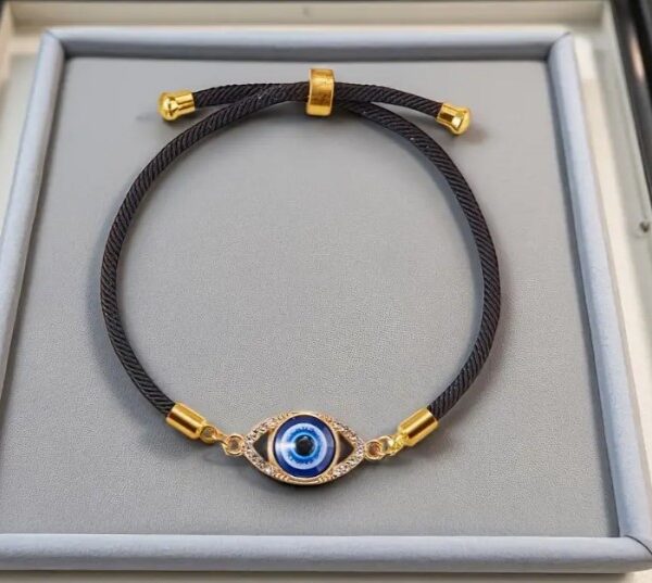 black adjustable bracelet with a blue evil eye  charm set in a gold-tone frame